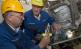 Zwei BASF-Mitarbeiter überprüfen an einer Amine-Produktionsanlage einen Sensor an einer Pumpe